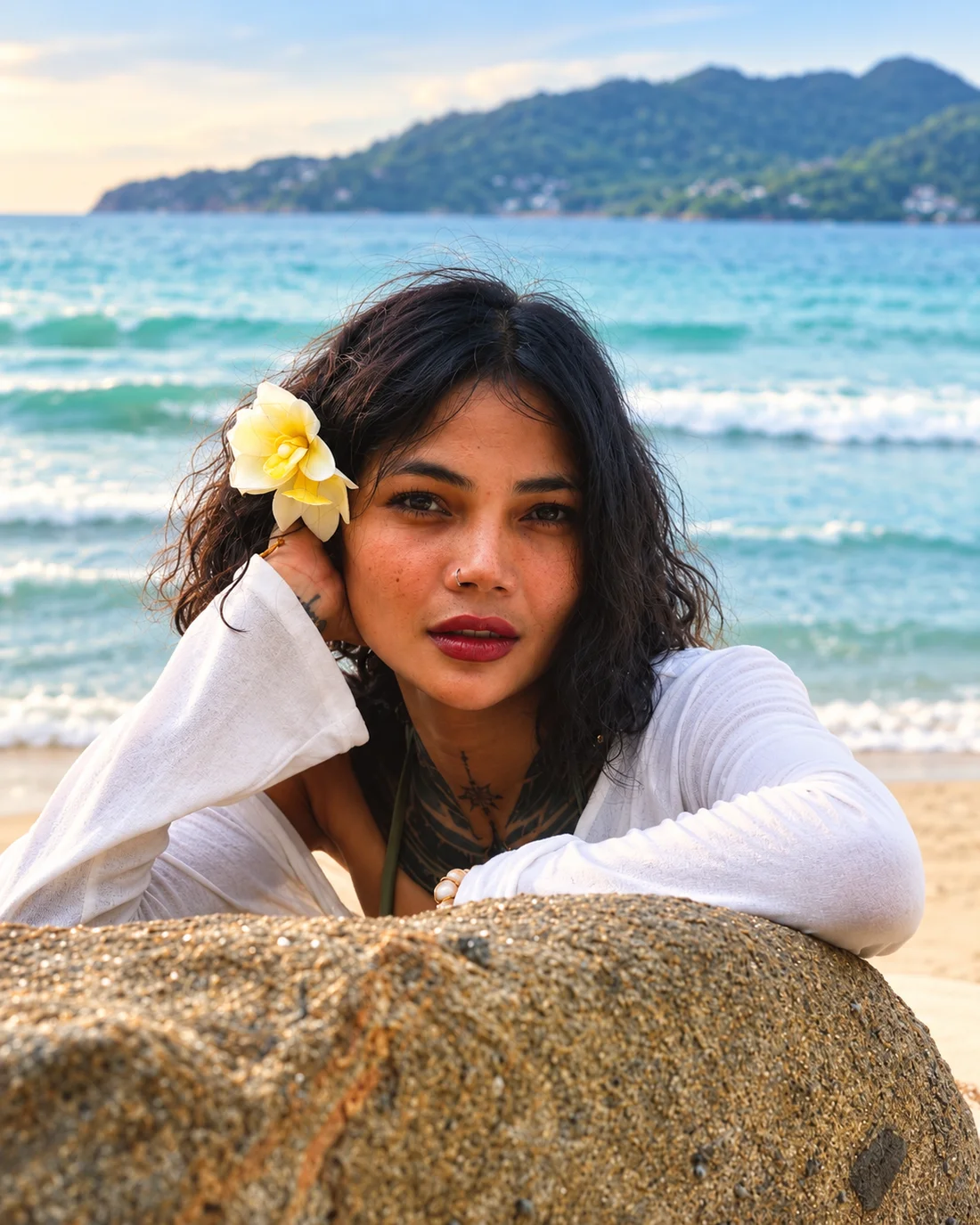 Portrait of Jinny outdoors by the sea, wearing a white flower in her hair